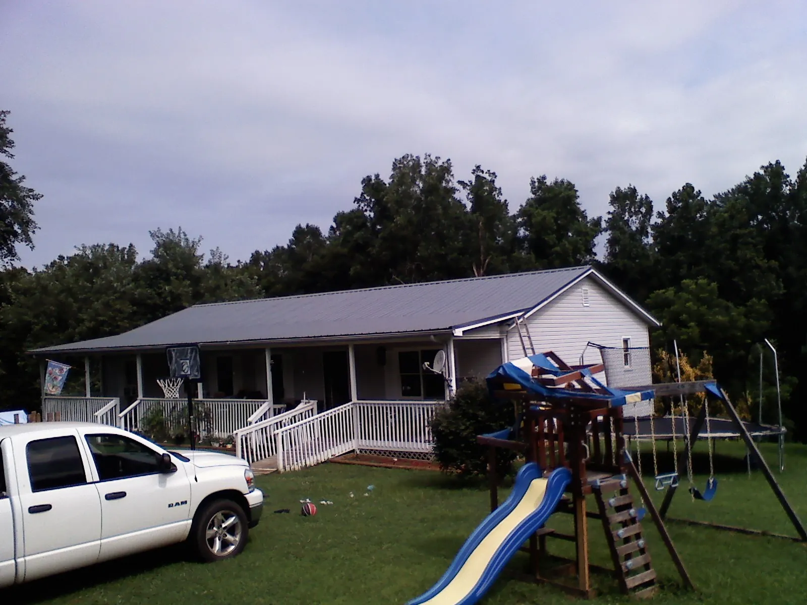 Dark metal roof on a country home with a full length front porch in Martinsburg